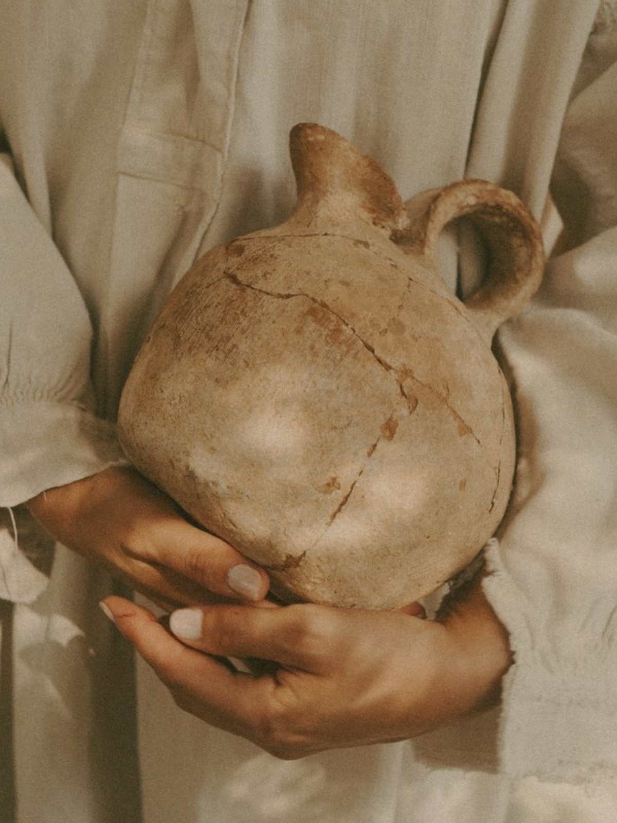 Hands holding clay jug